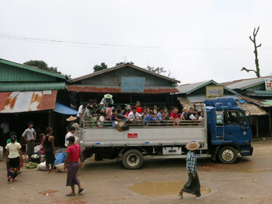 トラックの荷台に足をたたんでぎゅうぎゅうになって座る