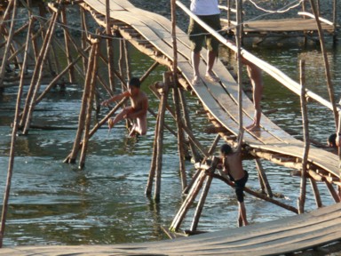 木の橋から清流へダイビングして楽しむ子供たち