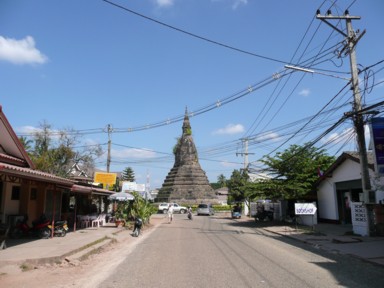 ビエンチャンの街なかの道路中央に立つ雑草が生えて古さが味を出すタート・ダムの仏塔