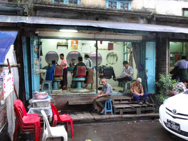 ヤンゴンの扉や壁のない半屋外の床屋の景色