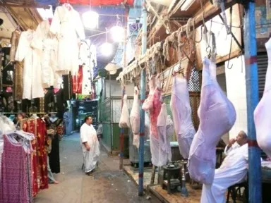 カイロのハーン・ハリーリの服屋の前の肉屋が羊の肉をいくつも吊るし白い服が血で染まっている光景