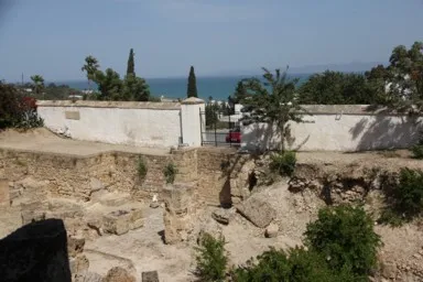チュニジアのカルタゴの遺跡の横に民家の塀がある景色