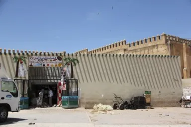フェズの屋根の飾りの影が壁に映る商店の光景