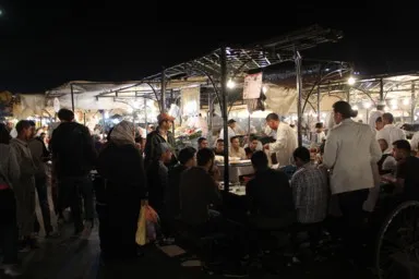 マラケシュのフナ広場の夜の屋台が並び人々が食事する光景