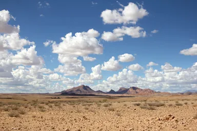 ナミビアのアフリカの大地を思わせる大地と山と低く見える雲の風景