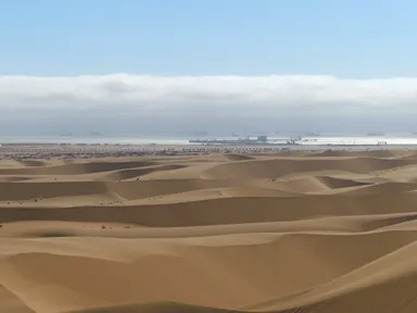 ウォルビス・ベイの続く砂丘の先に海がある景色
