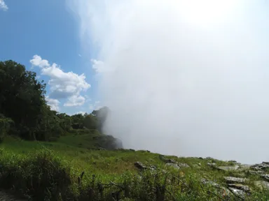 ヴィクトリアフォールズの水しぶきが崖の下から垂直に上空に舞い上がる姿