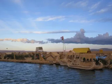 チチカカ湖に浮かぶトトラで作られたウロス島にトトラで作られた2階建ての船が止まる様子