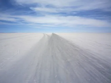 ウユニ塩湖の道なき道だけどわずかに黒ずんだ道を目的地も見えづに走る様子