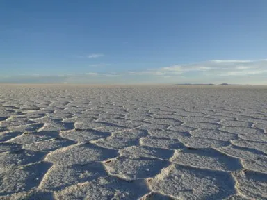 ウユニ塩湖の平らな大地の夕暮れは地面の塩の結晶に影ができ始める景色