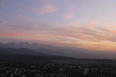 アルマトイのコク・トベの丘から見上げる雪をかぶった山脈の夕暮れの光景