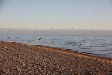 対岸天山山脈の壁がそびえるイシククル湖の景色