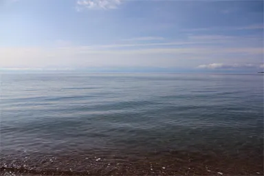 波のない穏やかなイシククル湖の湖畔