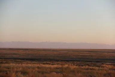 カザフスタンの何もない真っ平らな大地とはるか遠くに見える連なった山