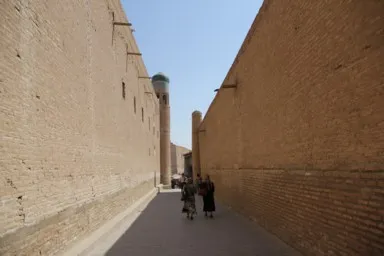 ヒヴァのレンガ造りの高い塀の真ん中を通る路地の景色