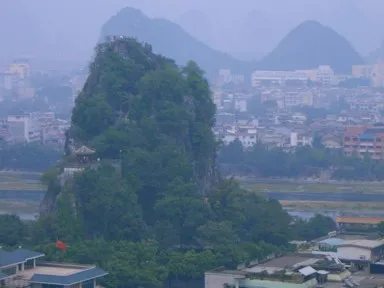 桂林の独秀峰の垂直に伸びる奇岩と中腹の建物