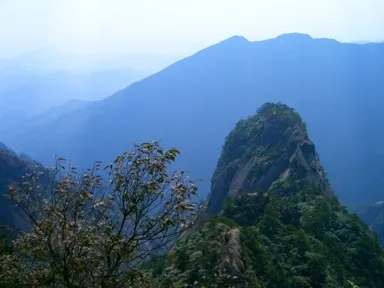 黄山の登山道から眺める奇岩と後ろにそびえる淡い山