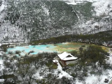 黄龍の雪をかぶった最上部にある五彩池と寺院