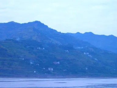 夕暮れの長江の岸沿いの家々からのぼる煙