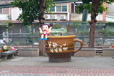 台湾の鶯歌老街の陶器のコップと女の子の像
