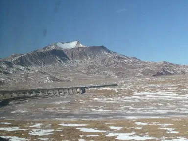 青蔵鉄道が走る雪山と雪が残る大地