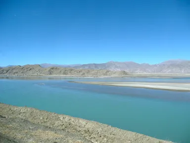 チベットの青い川と乾燥した荒れた大地