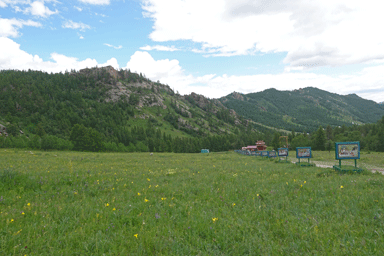 アリヤバル寺院のふもとに広がる花畑と山々の光景