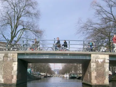 アムステルダムの運河クルーズの橋の上の自転車で行き交う人々の光景