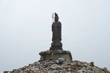 青森の恐山の仏像の頭にのる烏