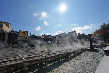 群馬の草津温泉の蒸気が上がる湯畑と太陽