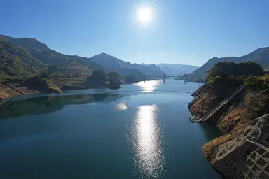 群馬の八ッ場ダムの太陽を反射する湖面と山々