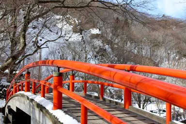 群馬の伊香保温泉の赤い橋と雪の山