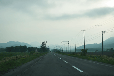 北海道の夕暮れのもやがかかったまっすぐに伸びる道