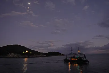 広島の鞆の浦の静かな夜の漁船と弁天島の小さな灯り