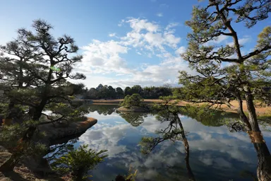 岡山の後楽園の庭園と空を映す沢の池