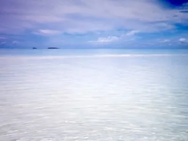 モルディブのオルヴェリの透明の遠浅の海が地平線まで続く光景