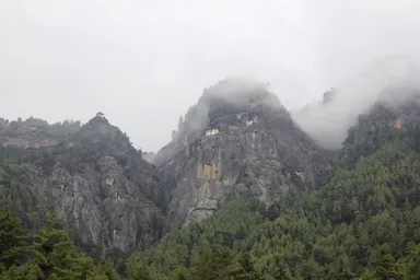 登山道入り口から眺める荒々しい山と中腹にはりつくタクツァン僧院の光景