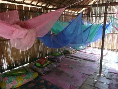 チェンマイ郊外の首長族の集落で藁引きの高床式の部屋に蚊帳がある風景