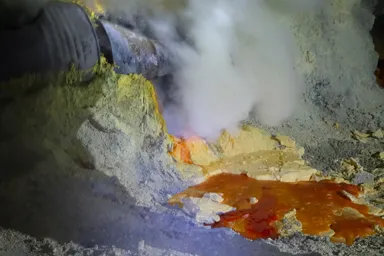 イジェン山の火山ガスが勢いよく噴出し黄色と赤の硫黄の塊