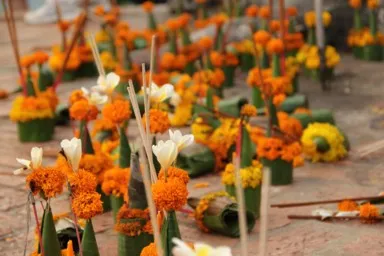 プーシーの丘に葉と色鮮やかな花で作られたお供え物が並んで置かれた様子