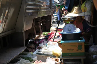 メークロン市場の列車と商品の食料品がギリギリ数センチのすれ違いをしている光景