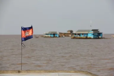 トンレサップ湖の水平線が広がる巨大な湖と水上の家とカンボジア国旗